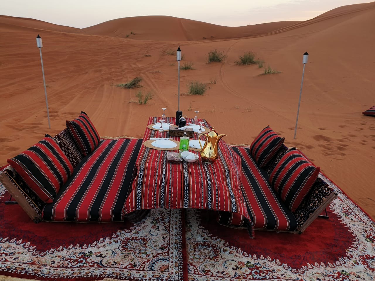 Private majlis with low dining table and striped cushions in Dubai dunes